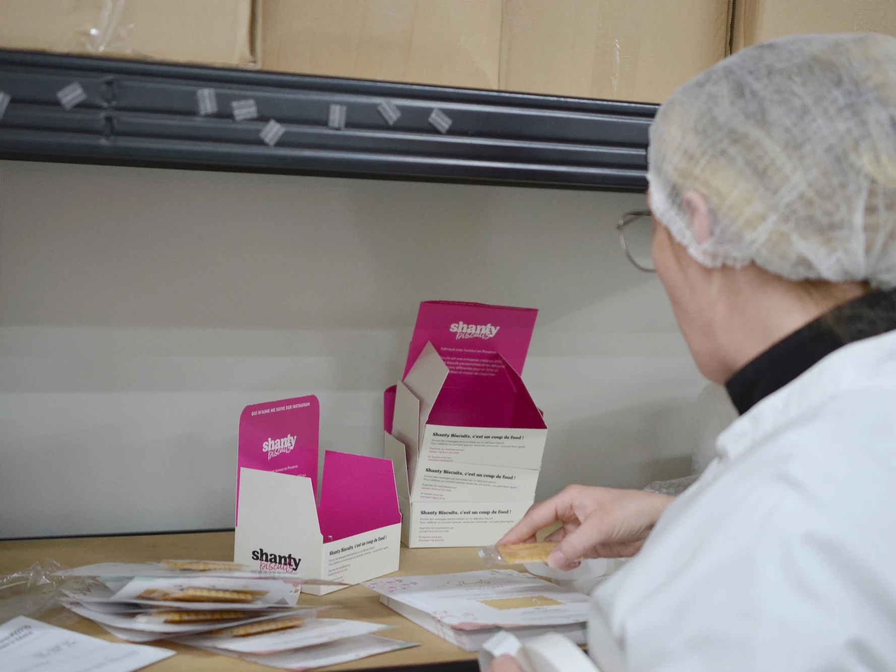 Shanty Biscuit emballant manuellement des biscuits sur la ligne de production